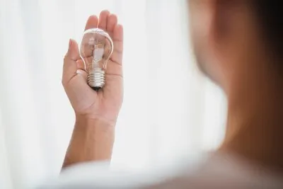 rear-view-man-s-hand-showing-transparent-light-bulb_23-2147817191_16_11zon